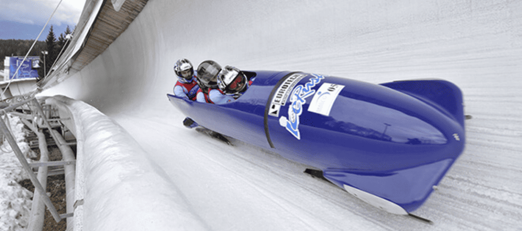 Ice bobsleigh with 3 people inside travelling quickly