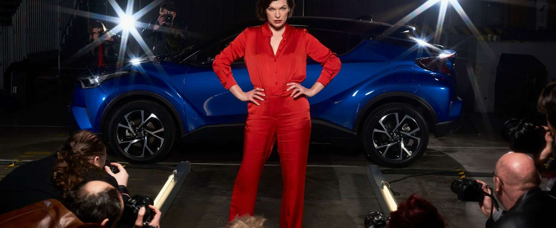 Milla Jovovich standing infront of the Toyota C-HR